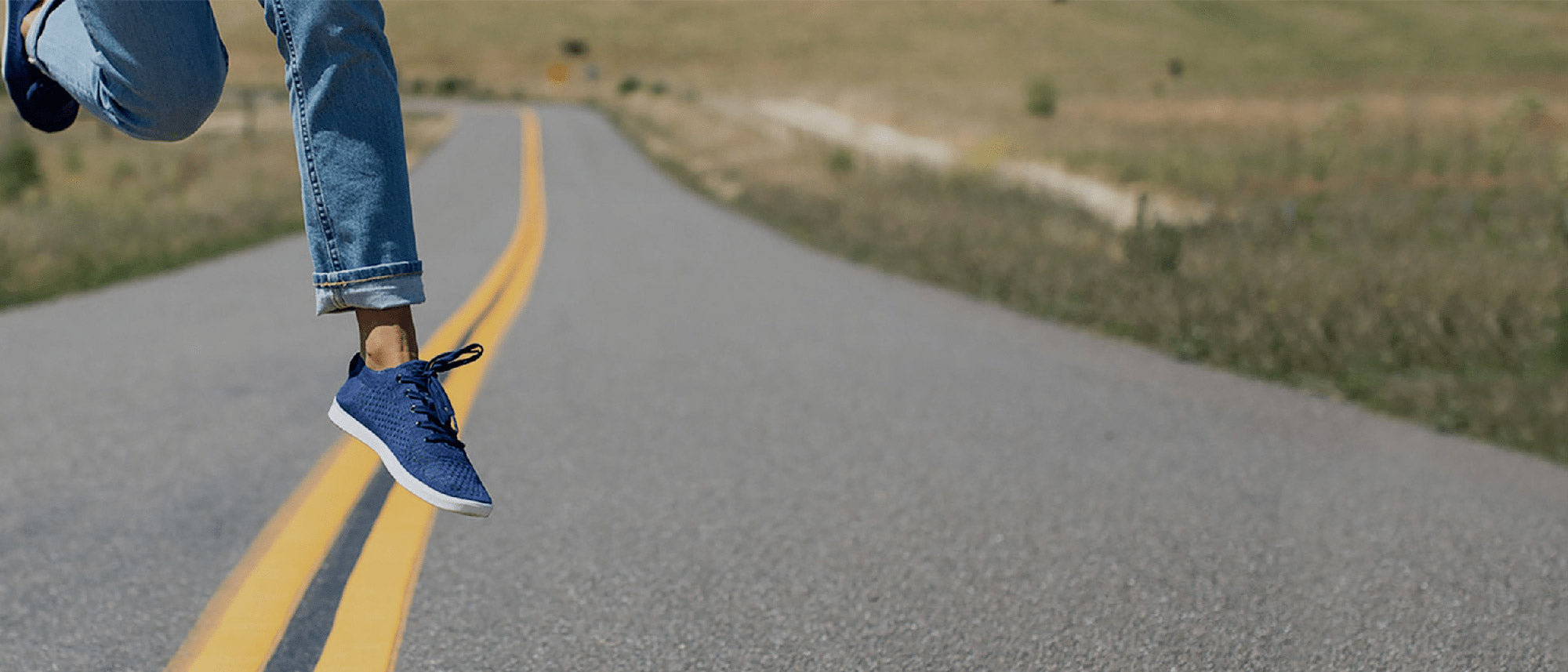 Woman jumping wearing The Navy Zilker low tops