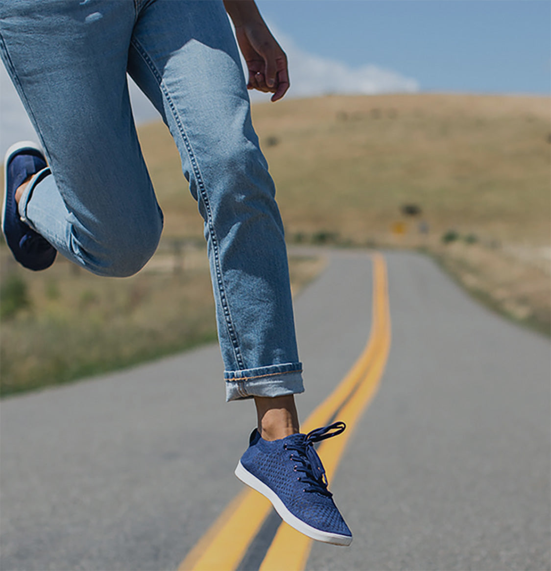 Woman jumping wearing The Navy Zilker low tops